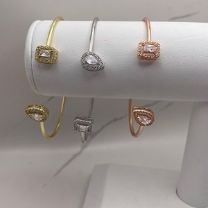 Open bangle with diamond cz ends. 18k gold plated.